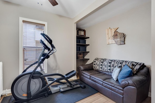 workout room with wood finished floors, ceiling fan, and baseboards