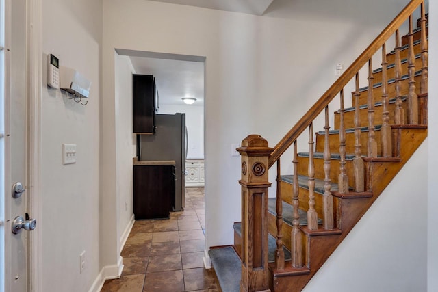 foyer entrance with baseboards and stairs