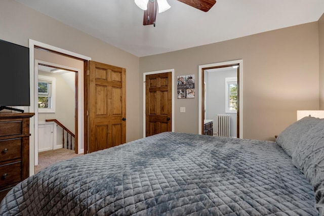 bedroom with radiator, multiple windows, carpet flooring, and ceiling fan