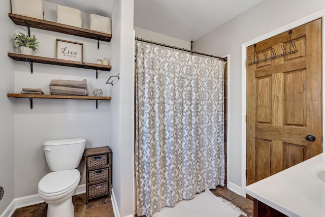 bathroom with toilet, baseboards, and curtained shower