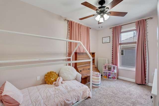 bedroom with radiator heating unit, carpet, a ceiling fan, and baseboards