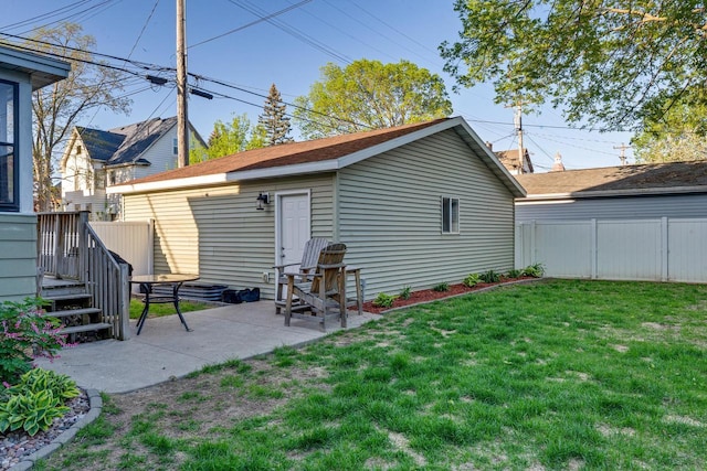 back of house with a patio and an outbuilding