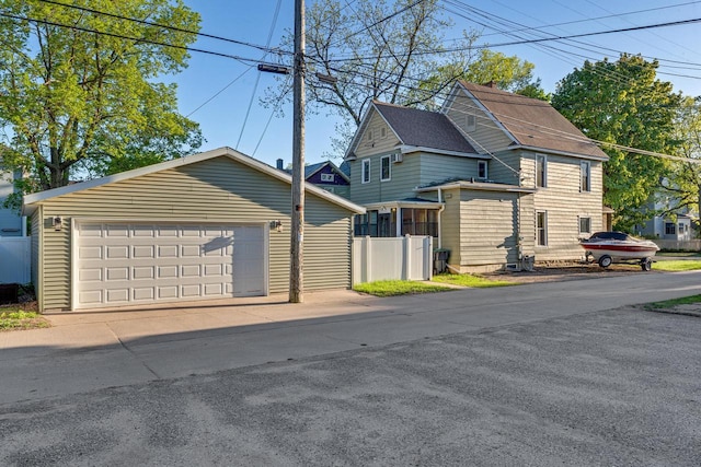 view of front of property featuring a detached garage and fence