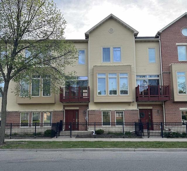612 N Midvale Blvd, Madison, WI 53705 - townhome / multi-family property with brick siding and a fenced front yard