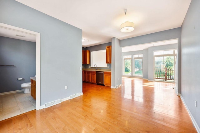 612 N Midvale Blvd, Madison, WI 53705 - unfurnished living room featuring light wood-style floors, baseboards, and a sink