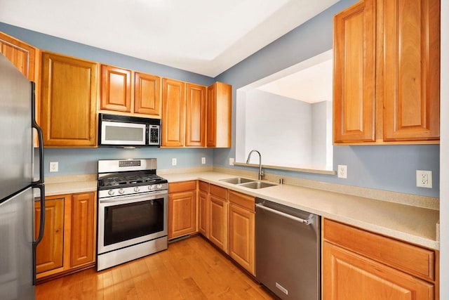 612 N Midvale Blvd, Madison, WI 53705 - kitchen featuring stainless steel appliances, a sink, light wood finished floors, light countertops, and brown cabinetry