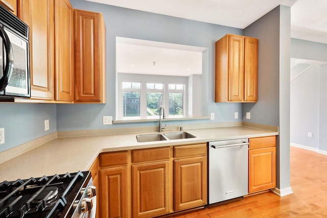 612 N Midvale Blvd, Madison, WI 53705 - kitchen with stainless steel appliances, a sink, light wood-style floors, light countertops, and brown cabinets