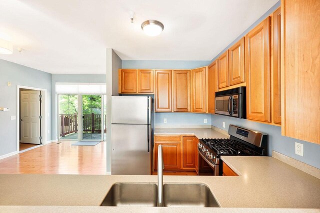 612 N Midvale Blvd, Madison, WI 53705 - kitchen with stainless steel appliances, a sink, light countertops, and wood finished floors