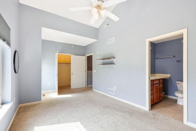 612 N Midvale Blvd, Madison, WI 53705 - unfurnished bedroom featuring light carpet, high vaulted ceiling, a walk in closet, baseboards, and ensuite bathroom