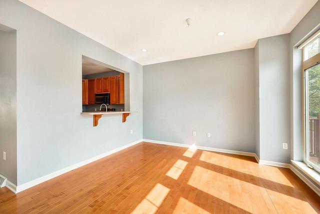 612 N Midvale Blvd, Madison, WI 53705 - unfurnished living room featuring light wood-type flooring, recessed lighting, baseboards, and a sink
