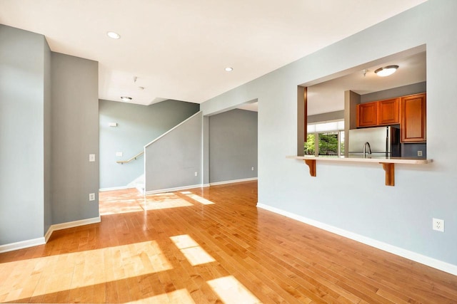 612 N Midvale Blvd, Madison, WI 53705 - unfurnished living room with light wood-style floors, stairs, baseboards, and recessed lighting