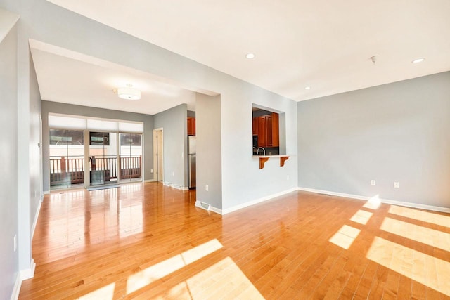 612 N Midvale Blvd, Madison, WI 53705 - unfurnished living room featuring light wood-style floors, baseboards, and recessed lighting