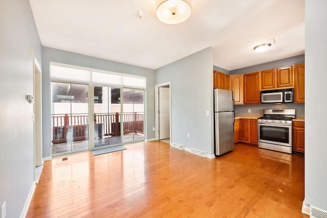 612 N Midvale Blvd, Madison, WI 53705 - kitchen with stainless steel appliances, light wood-style flooring, light countertops, and brown cabinets