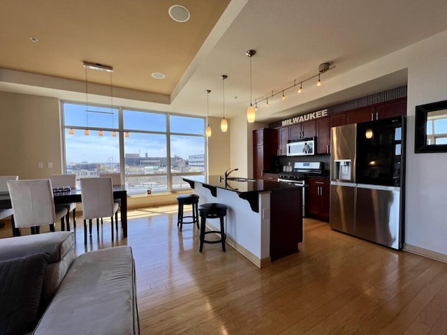 106 W Seeboth St Unit 503, Milwaukee, WI 53204 - kitchen featuring stainless steel appliances, dark countertops, a kitchen breakfast bar, and plenty of natural light