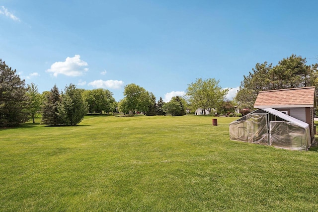 W308S2787 Wild Berry Ct, Waukesha, WI 53188 - view of green lawn featuring a greenhouse and an outbuilding