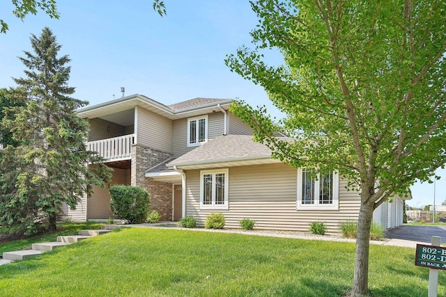 802 Herndon Dr Unit C, Madison, WI 53718 - view of front of home featuring a balcony, a front lawn, asphalt driveway, and roof with shingles