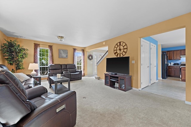 living room featuring light colored carpet and baseboards