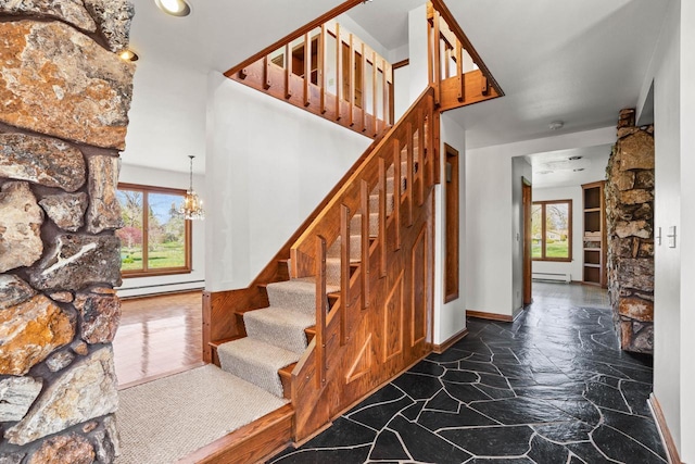 9 Sandalwood Ct, Wind Point, WI 53402 - stairs featuring a baseboard heating unit, stone flooring, a chandelier, and baseboards