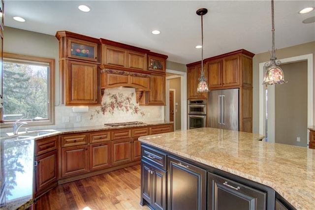 7379 124th St, Chippewa Falls, WI 54729 - kitchen featuring appliances with stainless steel finishes, backsplash, decorative light fixtures, light wood-type flooring, and glass insert cabinets