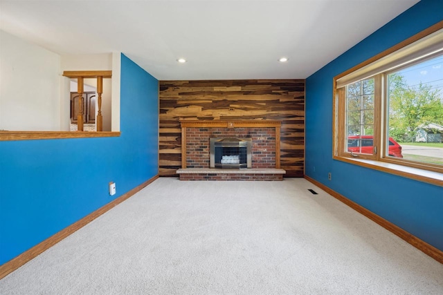 1820 Sampson St, Wisconsin Rapids, WI 54494 - unfurnished living room featuring wooden walls, baseboards, carpet, recessed lighting, and a brick fireplace