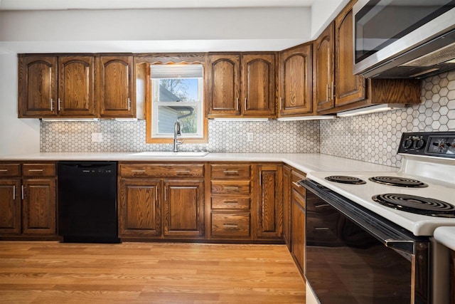 1820 Sampson St, Wisconsin Rapids, WI 54494 - kitchen with range with electric stovetop, stainless steel microwave, black dishwasher, a sink, and light countertops