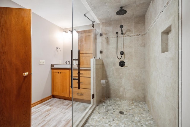 1820 Sampson St, Wisconsin Rapids, WI 54494 - bathroom featuring a tile shower, vanity, wood finished floors, and baseboards