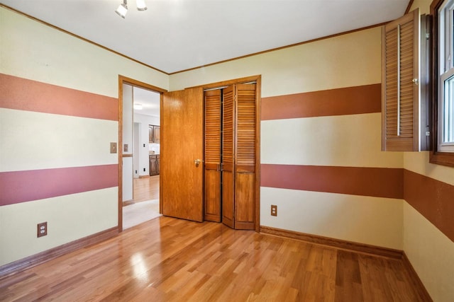 1820 Sampson St, Wisconsin Rapids, WI 54494 - unfurnished bedroom featuring wood finished floors, baseboards, and a closet