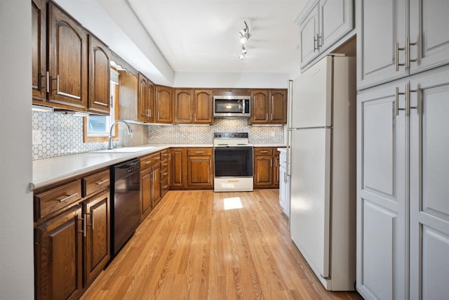 1820 Sampson St, Wisconsin Rapids, WI 54494 - kitchen featuring white appliances, a sink, light wood-style floors, light countertops, and decorative backsplash