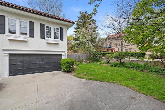 3468 N Summit Ave, Milwaukee, WI 53211 - view of side of home featuring stucco siding, an attached garage, concrete driveway, and a tiled roof