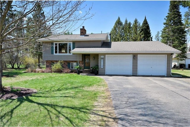 10237 Olker Rd, Hayward, WI 54843 - tri-level home featuring an attached garage, a chimney, a front lawn, asphalt driveway, and brick siding