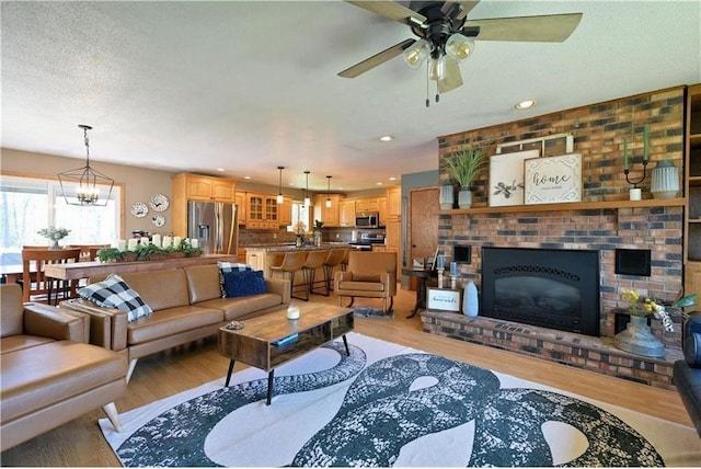 10237 Olker Rd, Hayward, WI 54843 - living area with light wood-style flooring, a ceiling fan, a chandelier, a fireplace, and recessed lighting