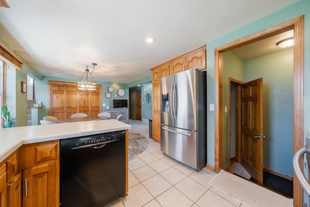 1083 Kenwood St, Green Bay, WI 54304 - kitchen with stainless steel fridge, black dishwasher, light countertops, light tile patterned floors, and decorative light fixtures