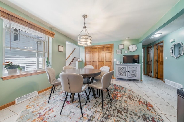1083 Kenwood St, Green Bay, WI 54304 - tiled dining area with a chandelier, stairway, and baseboards