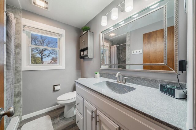 1083 Kenwood St, Green Bay, WI 54304 - bathroom with wood finished floors, a shower with curtain, vanity, baseboards, and toilet