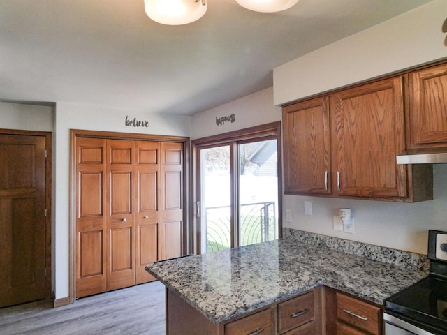 613 S Railroad St, Kimberly, WI 54136 - kitchen featuring electric range, brown cabinetry, light wood finished floors, a peninsula, and light stone counters