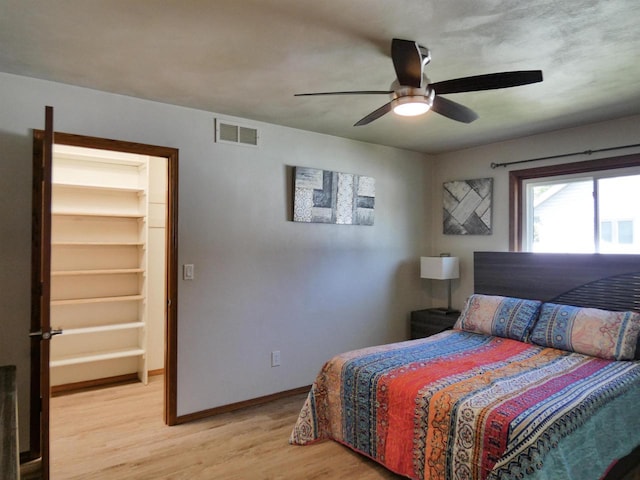 613 S Railroad St, Kimberly, WI 54136 - bedroom featuring a walk in closet, light wood-style flooring, baseboards, and a ceiling fan