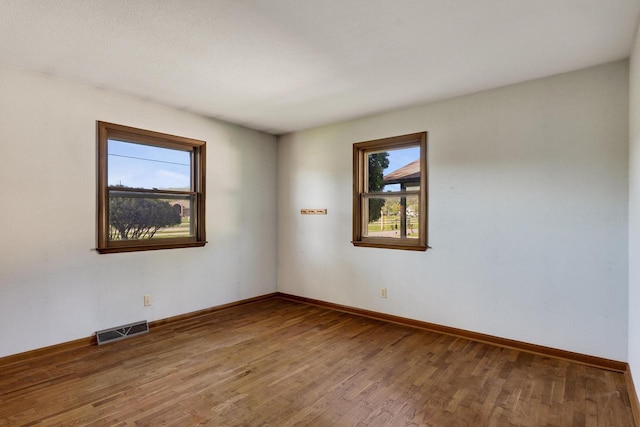 297 Walnut Dr, Onalaska, WI 54650 - empty room featuring plenty of natural light, wood finished floors, and baseboards