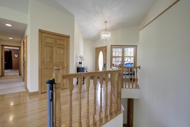 entryway featuring a chandelier, light wood-style flooring, recessed lighting, vaulted ceiling, and baseboards