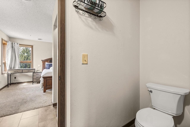 416 Sommers St, Stevens Point, WI 54481 - ensuite bathroom featuring toilet, a textured ceiling, tile patterned flooring, and baseboards
