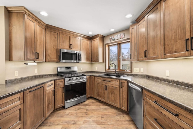 416 Sommers St, Stevens Point, WI 54481 - kitchen featuring stainless steel appliances, a sink, dark countertops, light wood finished floors, and recessed lighting