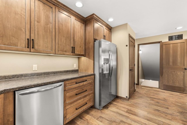416 Sommers St, Stevens Point, WI 54481 - kitchen featuring appliances with stainless steel finishes, dark countertops, light wood-type flooring, brown cabinetry, and recessed lighting
