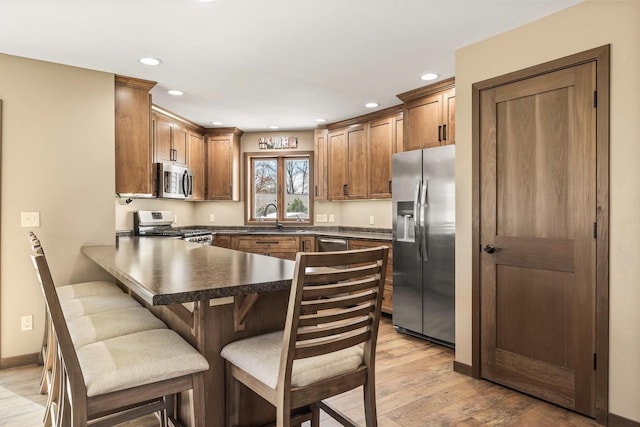 416 Sommers St, Stevens Point, WI 54481 - kitchen featuring stainless steel appliances, a sink, a peninsula, dark countertops, and recessed lighting