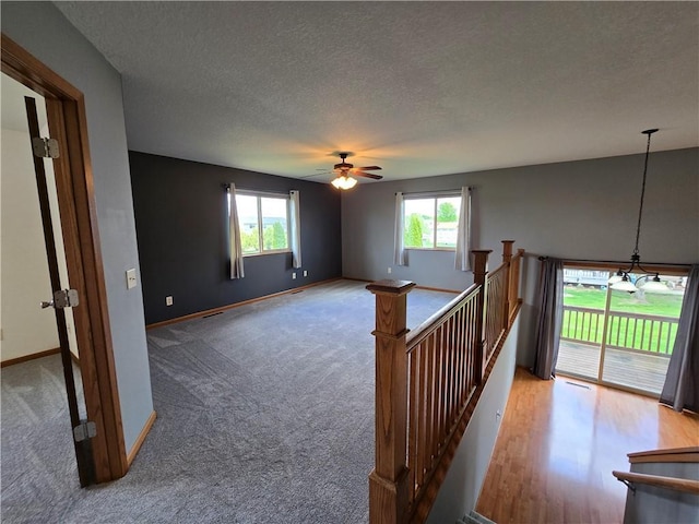 13570 42nd Ave, Chippewa Falls, WI 54729 - empty room with healthy amount of natural light, a textured ceiling, ceiling fan, baseboards, and carpet floors