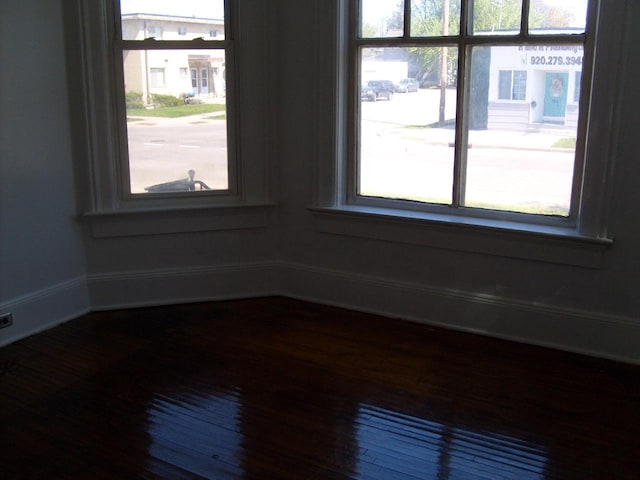 701 Otter Ave, Oshkosh, WI 54901 - unfurnished room with healthy amount of natural light, baseboards, and dark wood finished floors