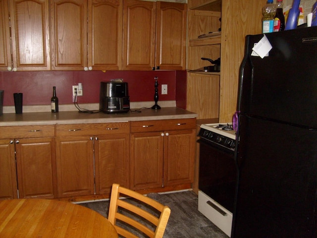 701 Otter Ave, Oshkosh, WI 54901 - kitchen featuring freestanding refrigerator, range with gas cooktop, brown cabinetry, and light countertops