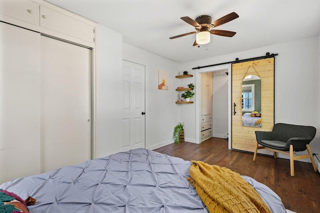 3486 Hargrove St, Madison, WI 53714 - bedroom with a barn door, dark wood-style flooring, baseboards, ceiling fan, and a closet