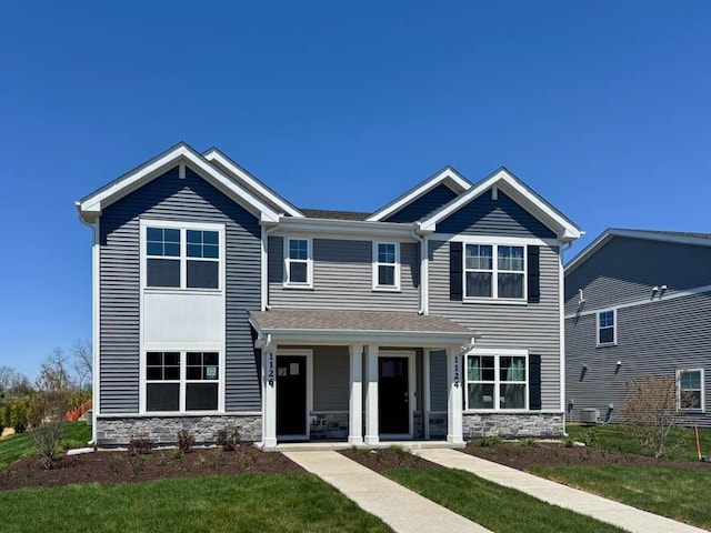 1126 58th Rd, Union Grove, WI 53182 - view of front of home with stone siding, a front lawn, covered porch, and central air condition unit