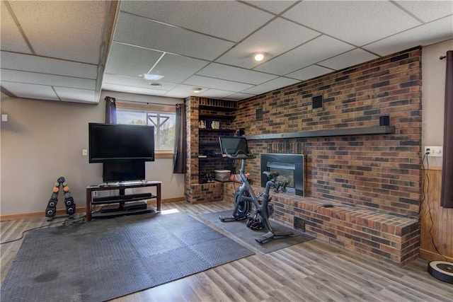 N492 County Road D, Eau Galle, WI 54737 - exercise room with wood finished floors, baseboards, a drop ceiling, brick wall, and a brick fireplace