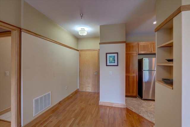 6767 Frank Lloyd Wright Ave Unit 219, Middleton, WI 53562 - kitchen featuring freestanding refrigerator, open shelves, and light wood-style floors