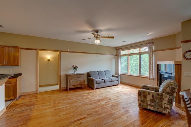 6767 Frank Lloyd Wright Ave Unit 219, Middleton, WI 53562 - living room featuring ceiling fan, light wood-style flooring, baseboards, and a tiled fireplace